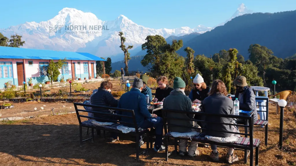 Trekkers from north nepal trek having lunch during mardi himal trek with backdrop of mount machhapuchre